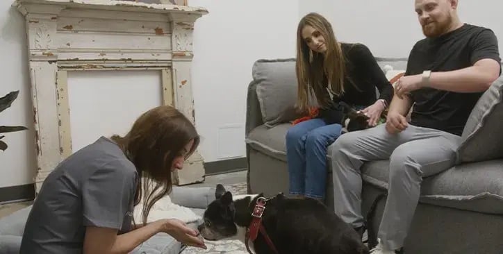 A family with their dog and a veterinarian in a Comfort Room